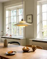Rivoli Pendel Ø40 Creme og messing fra Halo Design over et spisebord i et køkken Rivoli Pendel Ø40 Creme og messing fra Halo Design over et spisebord i et køkken