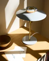 Rivoli Bordlampe Blank grå, messing fra Halo Design på et arbejdsbord i et kontor