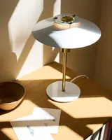 Rivoli Bordlampe Blank hvid, messing fra Halo Design på et skrivebord i et kontor Rivoli Bordlampe Blank hvid, messing fra Halo Design på et skrivebord i et kontor