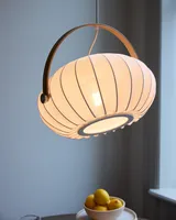 DC Textile Pendel Satinhvid fra Halo Design over et bord i en stue - blødt, varmt lys i hjemmet DC Textile Pendel Satinhvid fra Halo Design over et bord i en stue - blødt, varmt lys i hjemmet